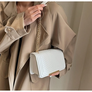 Elegant white chevron quilted crossbody bag with gold chain strap and metal trim