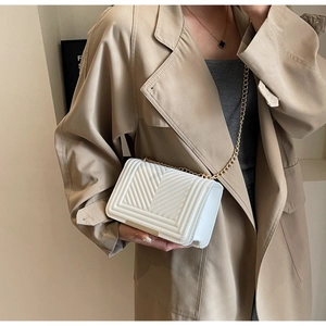 Detail showing white chevron quilted leather with elegant gold chain shoulder strap