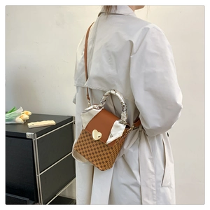 Detail of vintage brown plaid handbag with gold heart buckle and silk scarf handle