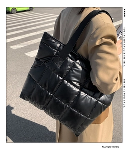 Détail du grand sac cabas matelassé noir brillant avec une large bandoulière souple
