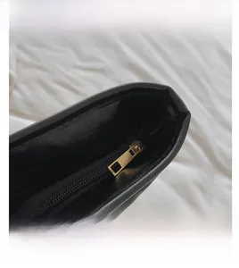 Gros plan de la fermeture éclair dorée sur le sac à bandoulière en coton matelassé