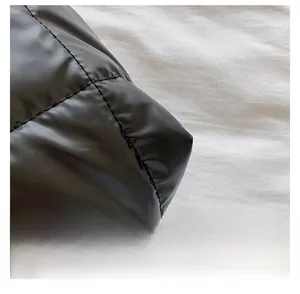 Détail de la texture matelassée noire et de la finition soignée des bords du sac à main