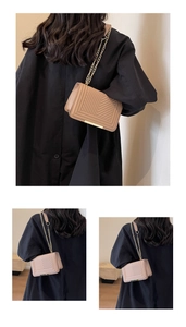 Detailed view of beige V-quilted chain strap crossbody bag with golden metal trim