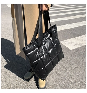 Détail du sac cabas noir en nylon matelassé avec surpiqûres carrées et poignées tissées