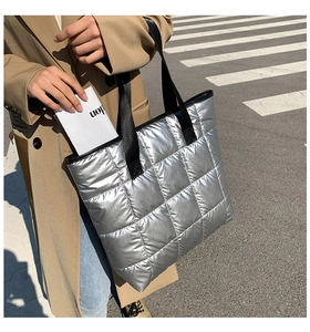 Détail d'un grand sac cabas matelassé argenté métallisé avec des bretelles en nylon noir