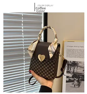 Detail of coffee brown plaid handbag with golden heart lock and silk ribbon wrap