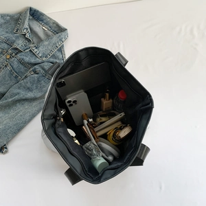 Intérieur spacieux du sac cabas matelassé noir contenant un ordinateur et des accessoires