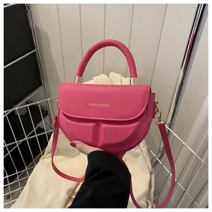 Detalle de bolso bandolera magenta semicircular con texto dorado FASHION & BAGS