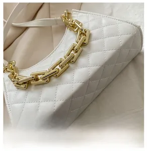Détail de la base du sac matelassé blanc et de sa bandoulière en chaîne dorée