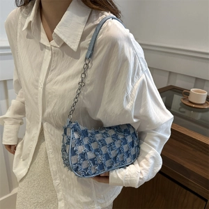 Blue checkerboard denim crescent bag with fringe edges and metal chain strap