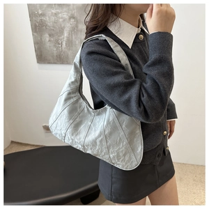 Silver textured crescent underarm bag shown on model for style and scale reference