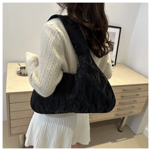 Detail of black crescent shoulder bag featuring textured crinkle finish and large capacity