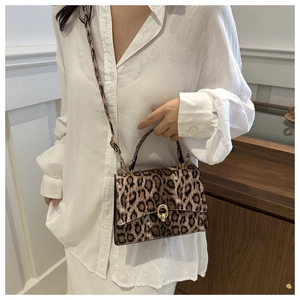 Detail of leopard print handbag featuring a gold metal twist lock and soft faux fur texture
