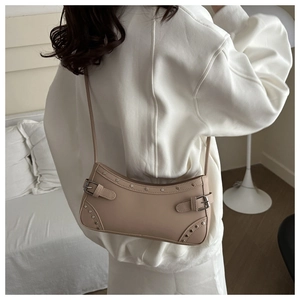 Borsa sottobraccio beige con borchie argento e dettagli fibbia su sfondo minimalista