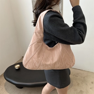 Fashionable peach pink pleated hobo tote bag for women shown as a casual shoulder bag