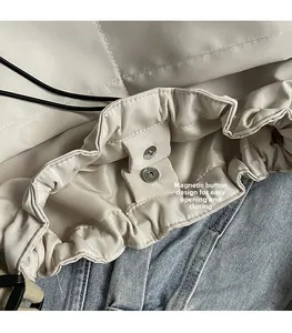 Detail van beige nylon emmertas met handige magneetsluiting en trekkoordsluiting