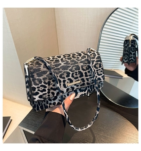 Détail du sac léopard avec boucle dorée et vue sur les compartiments intérieurs au miroir