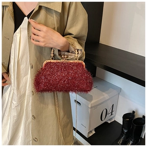Détail du sac de soirée pailleté bordeaux avec poignée en perles et chaîne dorée