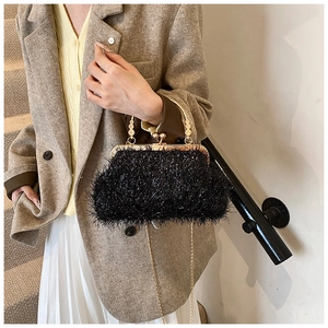 Détail du sac de soirée noir en peluche avec poignée dorée et bandoulière chaîne