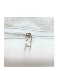 Detailed macro shot of white canvas tote bag closure with smooth silver metal zipper