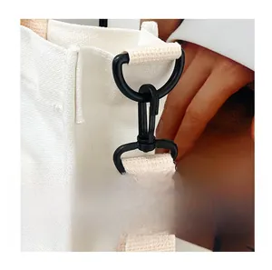 Detailed close-up of a white canvas tote bag with a black D-ring hook and woven strap