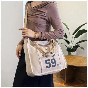 Detail of beige canvas tote bag with 59 runway print and adjustable shoulder strap