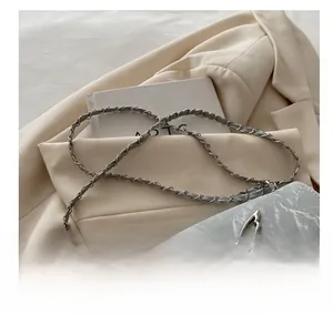 Detail of grey marble pattern crossbody bag with silver butterfly clasp and chain strap