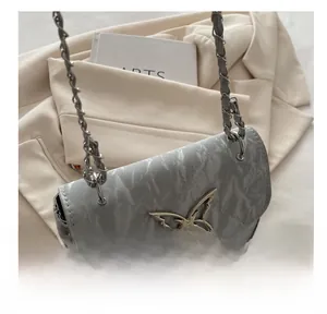 Close-up of marble texture crossbody bag with silver butterfly buckle and chain strap