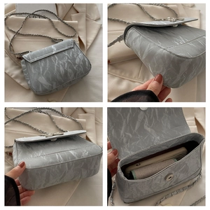 Detail view of grey marble texture crossbody bag with silver chain strap and inner pocket