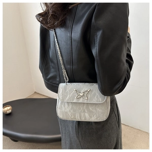 Chic grey mini shoulder bag with textured leather and a metallic butterfly charm