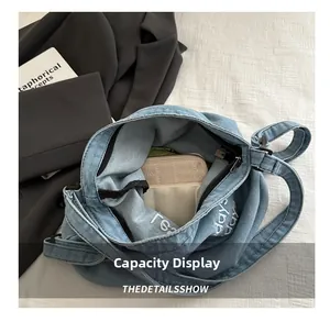 Top view of blue denim tote bag interior showing large capacity for long wallet and items