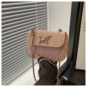 Detail of pink crossbody bag featuring a crushed texture and silver butterfly buckle