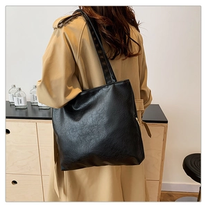 Detail of minimalist black large tote bag made of high-quality crinkled PU leather texture