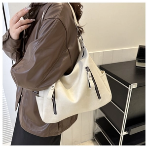 Detail of cream white faux leather tote bag with vertical zippers and adjustable strap