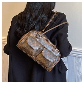 Brown vintage faux leather tote bag with distressed texture shown on woman's shoulder