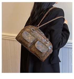 Detail view of vintage brown faux leather shoulder bag with pockets and silver hardware