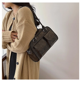 Detail shot of vintage brown leather shoulder bag with pockets and silver D-ring hardware