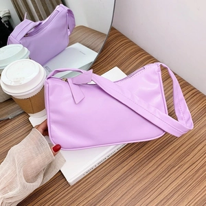 Close-up of lavender PU leather handbag with wide shoulder strap and zipper detail