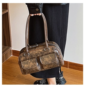 Detail of a brown vintage leather tote with double front pockets and industrial chic style