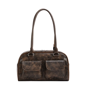 Vintage brown leather shoulder bag with dual front pockets and long straps on white background