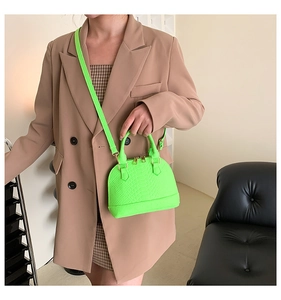 Fluorescent green shell bag with snake skin pattern showing hand-held and crossbody style