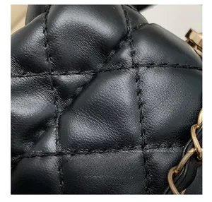 Close-up of premium black quilted leather texture with classic diamond pattern and gold chain