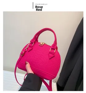 Detailed view of rose red crocodile pattern shell bag with premium gold hardware accents