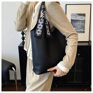 Black pebbled leather tote bag with a checkered silk scarf detail on the handle
