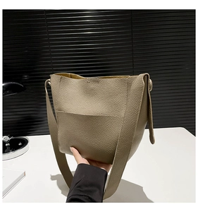 Detail of khaki bucket bag showing premium lychee grain texture and flat front pocket
