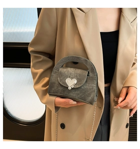 Detail view of mini retro green shoulder bag with silver heart lock and chain strap