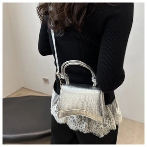 Silver crocodile textured hourglass handbag with metal chain strap shown on model