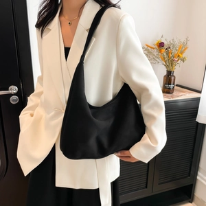 Minimalist black crescent tote bag with large capacity shown on a model in a studio