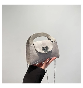 Close-up of mini grey crossbody bag with silver heart buckle and wide handle detail
