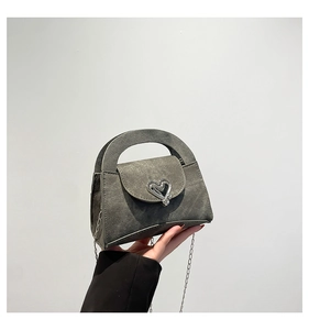 Detail of grey denim textured mini bag with oversized silver heart metal buckle